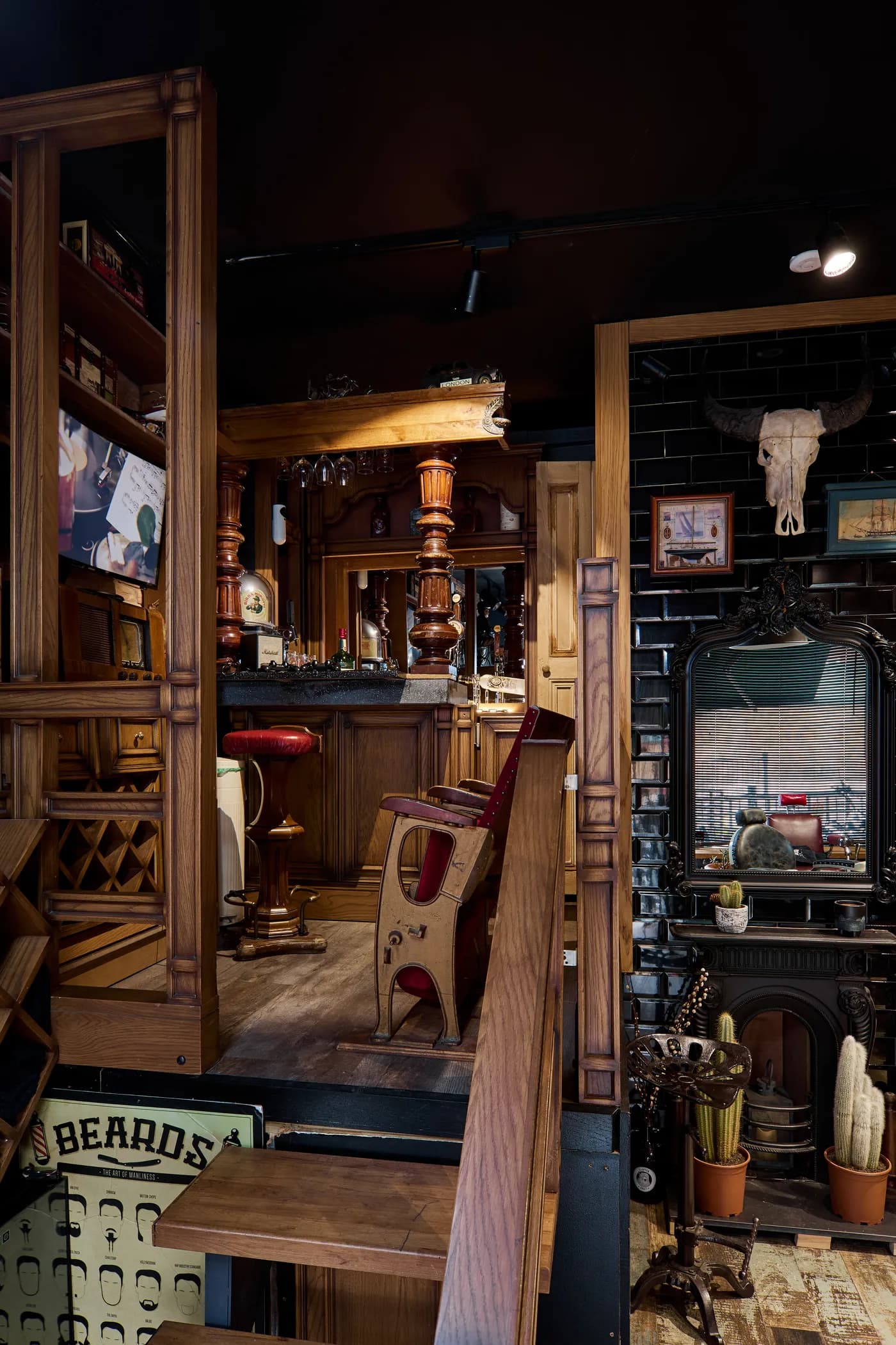 The bar end of the shop: cabinets, a mirror, a fireplace and a second barber's chair